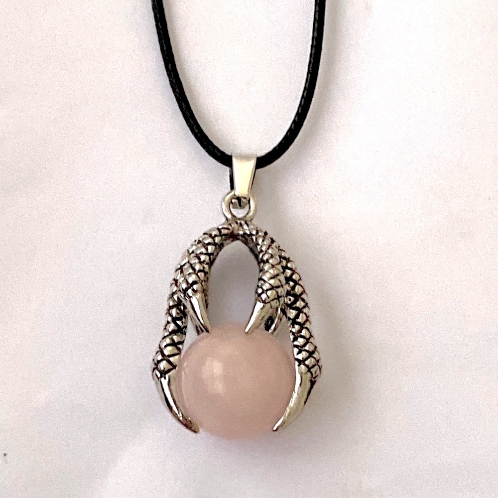 Dragon claw holding rose quartz orb.  On a leather with clasp chain